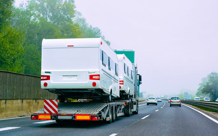 Truck carrier with motor homes rv on road