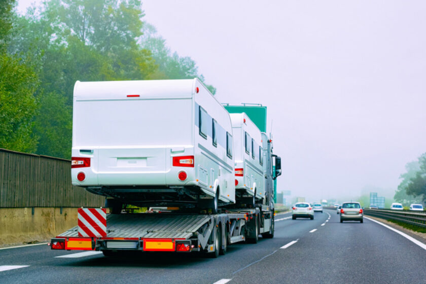 Truck carrier with motor homes rv on road