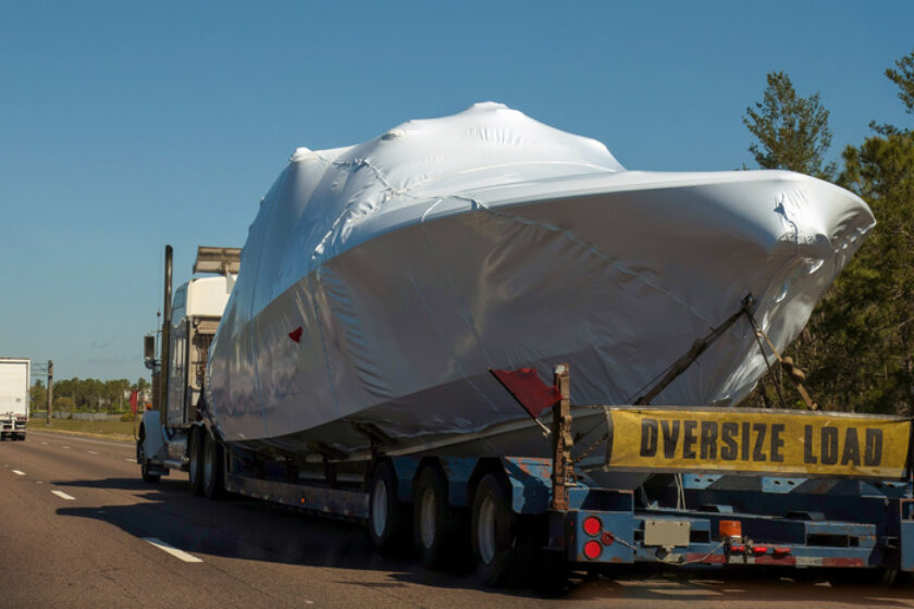 boat shipping - Transportation of a pleasure boat, yacht by heavy loading truck on the highway.